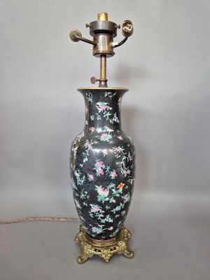 une image représentant un vase noir et rose avec un socle doré