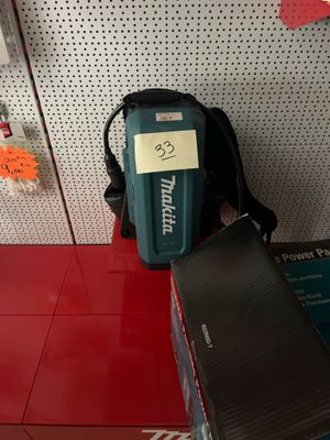 un sac à dos posé sur une étagère à côté d'une boîte