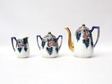 three pieces of porcelain tea set on a white surface
