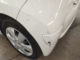 a white car that has been dented and is in a garage