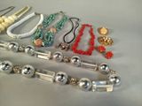 many different types of necklaces and bracelets laid out on a table