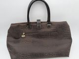 the brown crocodile skin handbag is on a white surface