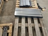 many pieces of metal on a pallet in a warehouse