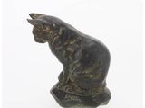 statue of a cat sitting on a rock on a white background