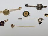many different types of pins and brooches on a white surface