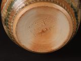 a close up of a vase on a black surface
