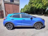 a blue car parked in a parking lot next to a building