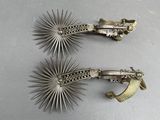 pair of antique silver metal hair clips with starbursts on them