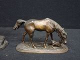 a bronze statue of a horse and a mouse on a table