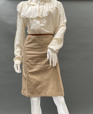 an image of a mannequin wearing a tan skirt and a white blouse