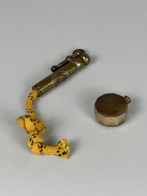 un petit serpent en plastique posé à côté d'un objet métallique