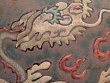 a vase with a dragon on it sitting on a table