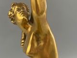 a gold vase with a bird on top of it