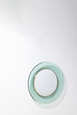 a small round mirror on the wall above a sink