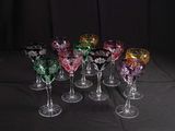 six different colored wine glasses sitting on top of a black table