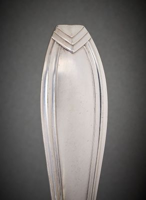 a silver vase on a table with a black background