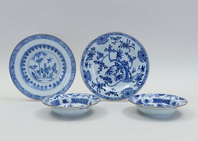 three blue and white plates with flowers and birds on them