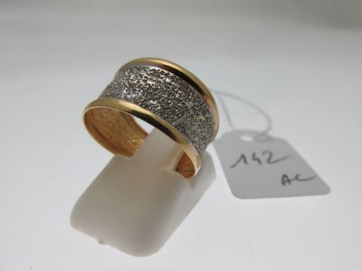 une bague en argent et en or à laquelle est accrochée une étiquette