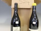 two bottles of wine sitting next to each other on a table