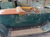 a green car with a surfboard on the back of it