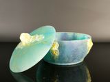 a blue bowl with a lid sitting on a black surface
