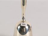 silver plated bell with the word go on it sitting on a white surface