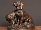 statue of two dogs sitting on top of a wooden table
