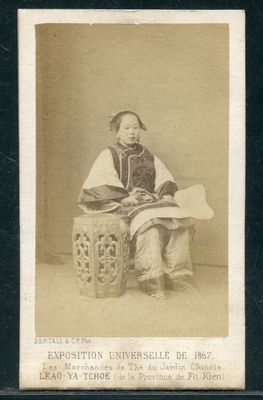 une vieille photo en noir et blanc d'une femme assise sur un tabouret