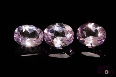 trois saphirs roses posés sur une surface noire