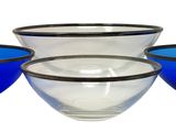three blue and clear glass bowls sitting on top of a white surface
