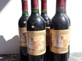 three bottles of red wine are lined up on a table