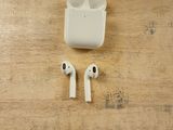 a pair of airpods sitting on a wooden table