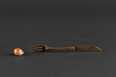 a close up of a fork and a piece of food on a black surface