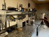 a man that is standing in a kitchen looking at something