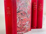 three red books sitting on top of each other on a table