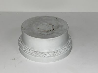 un gâteau argenté posé sur une table blanche, devant un fond blanc