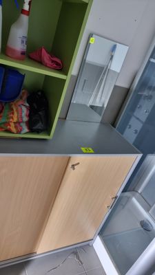 a green shelf with cleaning supplies on top of it