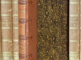 un livre posé sur une table, devant une pile de livres