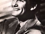 an old black and white photo of a smiling man in a suit