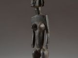 a statue of a man standing on a wooden base