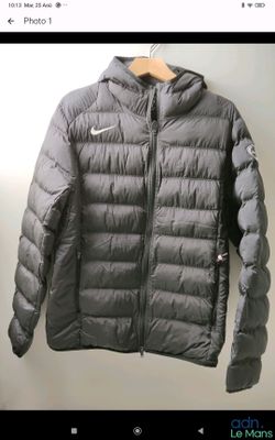 the jacket is hanging on a hanger on the wall