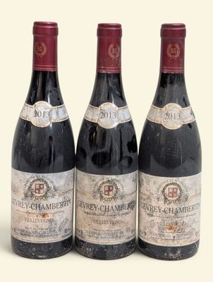 trois bouteilles de vin rouge posées l'une à côté de l'autre sur une surface blanche