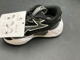 a black and white shoe with a tag attached to it