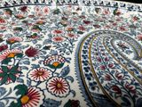 a close up of a bed with a paisley design on it