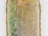un pendentif en jade vert et or orné d'un dragon