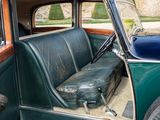 a green car with a black seat and a suitcase in the back