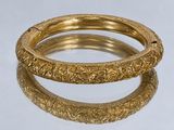 deux bracelets en or ornés de motifs complexes sur un fond blanc