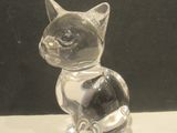 a glass figurine of a cat sitting on a table