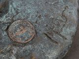 a coin sitting on top of a rock with writing on it