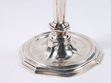 a silver candle holder on a white table